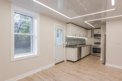 Потолок с глянцевым покрытием и световыми решениями на кухне