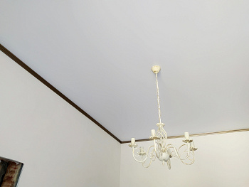 Матовый натяжной потолок с классической люстрой